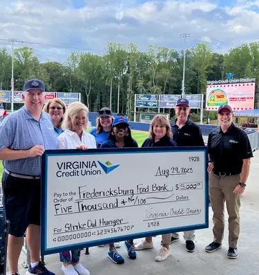 VACU team poses with large check in support of Fredericksburg Regional Food Bank