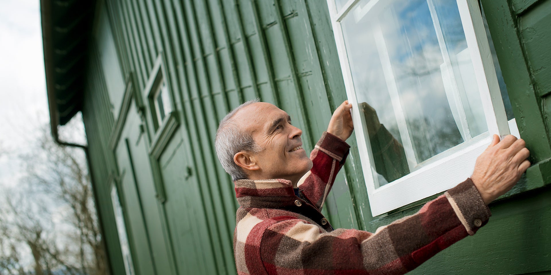 Man putting on new windows of a shed