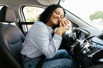 woman leaning on car steering wheel