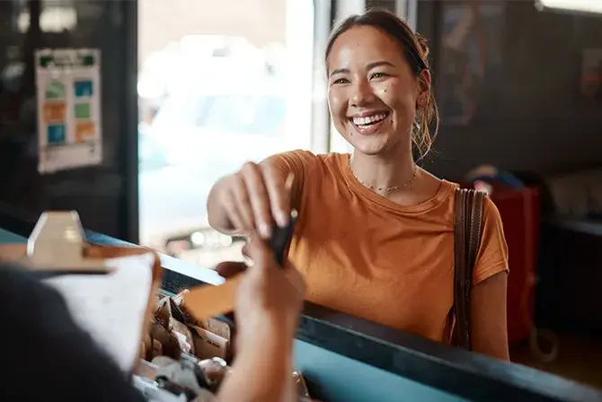 Woman smiles as she receives her car keys back from the mechanic.