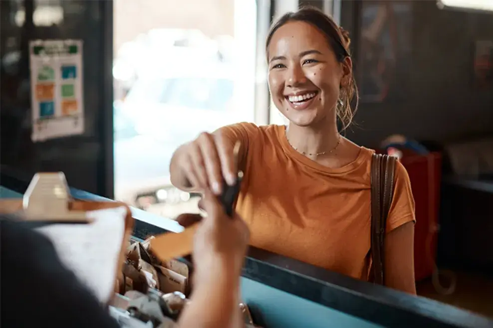 Woman smiles as she receives her car keys back from the mechanic.