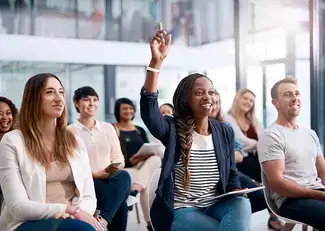 Woman raises her hand during a seminar 