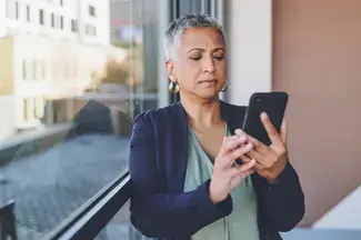 Woman looks at her phone with skepticism.