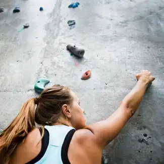A woman climbing a rock wall.