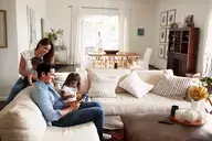 A family sitting on sofa together.