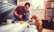 man with dog doing home improvement