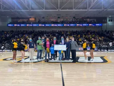 VACU presenting a check to members of the Children's Hospital of Richmond during a VCU basketball game