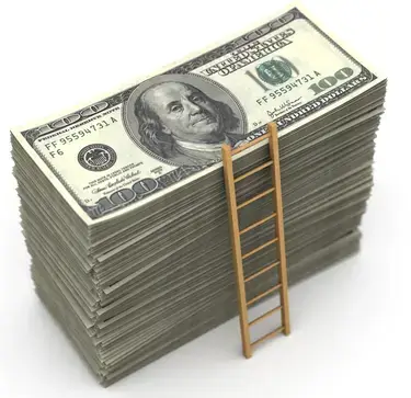 A small ladder going to the top of a stack of dollar bills.
