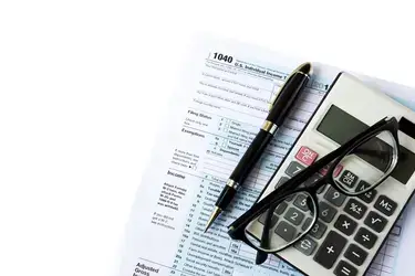 tax return form, pen, calculator and glasses