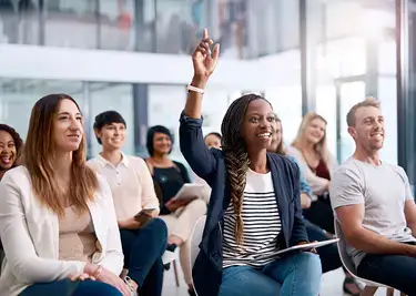 Woman raises her hand during a seminar 