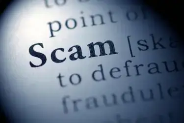A close up of the dictionary definition for the word "scam."