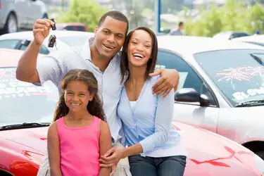 A happy family holding a new set of car keys.