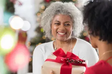 A woman giving a wrapped gift.
