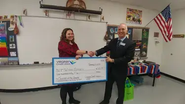 Teacher of the Quarter Melissa Hansen receiving a check from VACU staff.