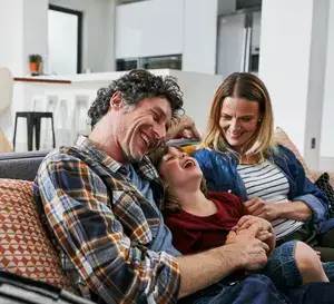 Family laughing on couch.