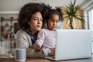 Mom and daughter using a laptop computer.