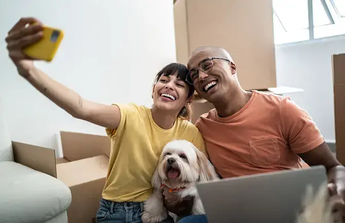 A couple taking a selfie with their dog