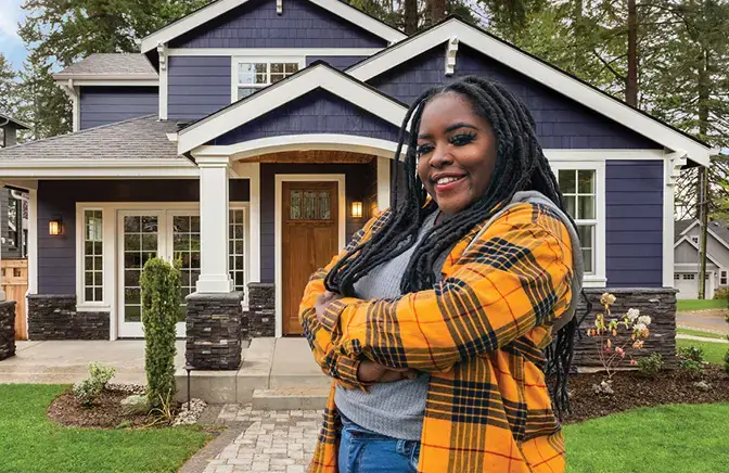 A woman standing in front of her home