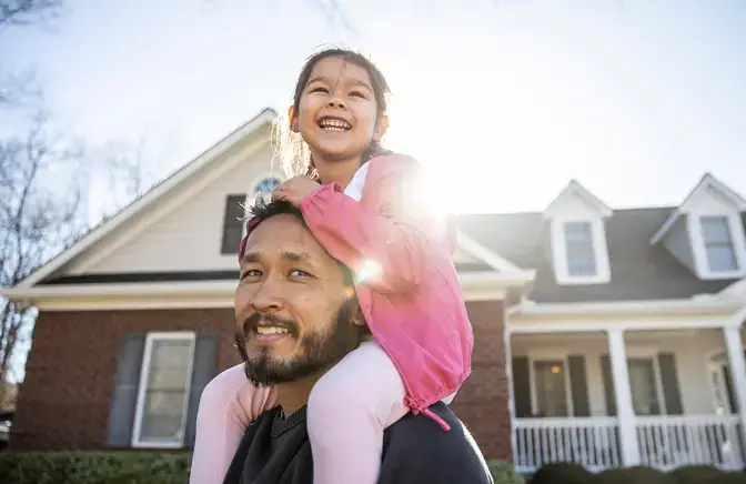 A father with his daughter on his shoulders