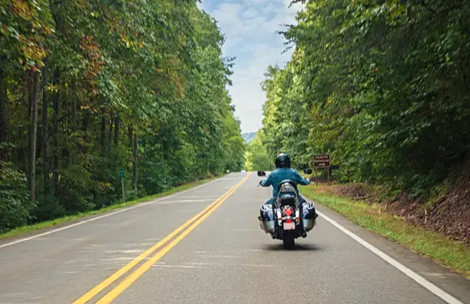 person driving down a road on a motorcycle