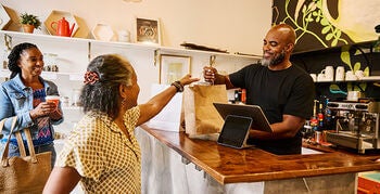 Two women purchasing products from a small business shop
